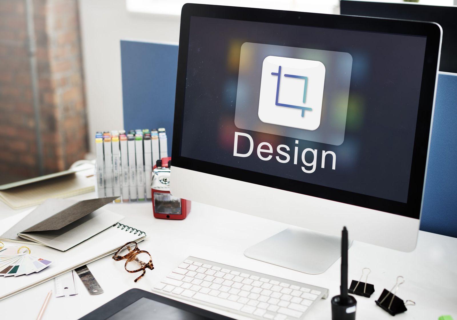 A monitor displaying the text "Design" on the screen